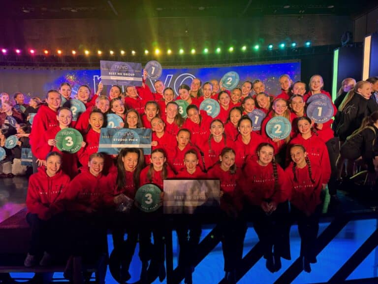 Group of dancers in red hoodies from Elite Dance Studio holding awards at the Nuvo Dance Convention in Bellevue, January 2025.