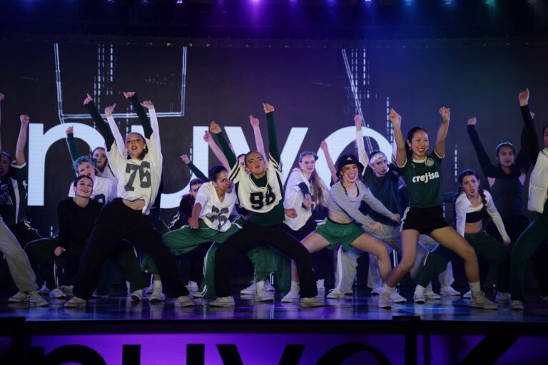 Hip hop dance group performing energetically on stage at Nuvo Dance Convention 2025 in Bellevue.